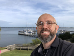Jared Dasbach smiling in front of a marina.
