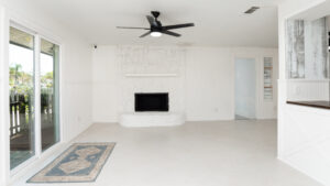 Real Estate interior A white living room with sliding glass doors, enhanced by virtual staging.